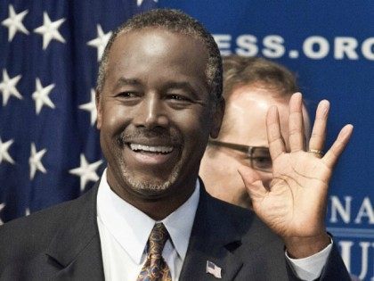 Ben Carson waves to the crowd as he arrives to discuss his new book 'A More Perfect Union: What We the People Can Do To Reclaim Our Constitutional Liberties' October 9, 2015 at the National Press Club in Washington, DC. AFP Photo/PAUL J. RICHARDS (Photo credit should read