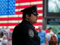 New York Police Officer keeps an eye on tourist as he stands guard at Times Square on July 4, 2015 in New York City. Security was heightened with more than 7.000 NYPD officers at landmark places and crowded streets after that the Federal Bureau of Investigation and the Department of …