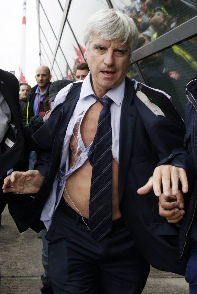 Pierre Plissonnier, nearly shirtless, is led away from demonstrators by security officers. (KENZO TRIBOUILLARD/AFP/Getty Images)