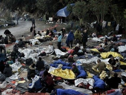 A photo taken on October 5, 2015 shows refugees and migrants a day after they spent a night in a field on the Greek island of Lesbos after crossing the Aegean sea from Turkey on October 5, 2015.