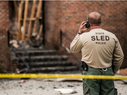 An Investigator with the State Police examines the burned ruins of the Mt. Zion AME Church