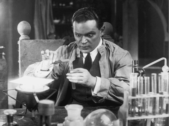 A scientist with staring eyes pours liquid from one test tube to another in a laboratory scene from an unknown German film.