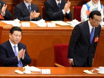China's President Xi Jinping (L) claps as Premier Li Keqiang (R) bowing at the beginning of the opening session of the National People's Congress (NPC) at the Great Hall of the People on March 5, 2014 in Beijing, China. China plans to raise defense budget by 12.2 percent to 808.2 …