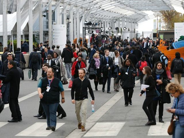 Conference attendees walk in the COP 21 United Nations conference on climate change, on November 30, 2015 in Le Bourget, on the outskirts of the French capital Paris. More than 150 world leaders are meeting under heightened security, for the 21st Session of the Conference of the Parties to the …