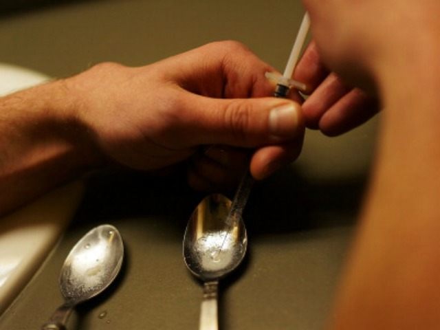 Drugs are prepared to shoot intravenously by a user addicted to heroin on February 6, 2014