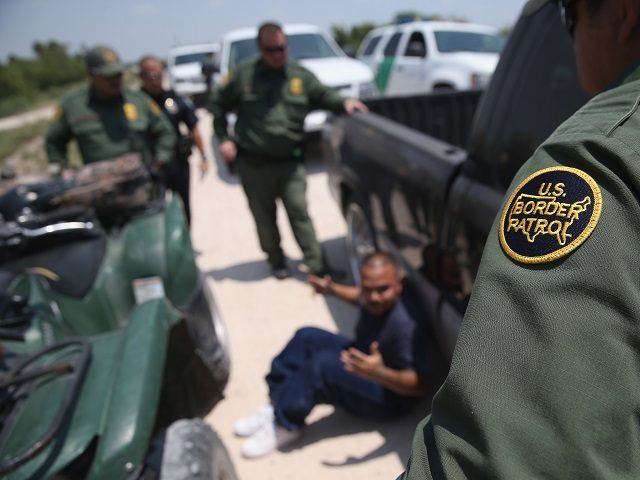 MISSION, TX - JULY 24: U.S. Border Patrol agents detain a suspected smuggler after he allegedly transported undocumented immigrants who crossed the Rio Grande from Mexico into the United States on July 24, 2014 in Mission, Texas. Tens of thousands of undocumented immigrants, many of them unaccompanied minors, have crossed …