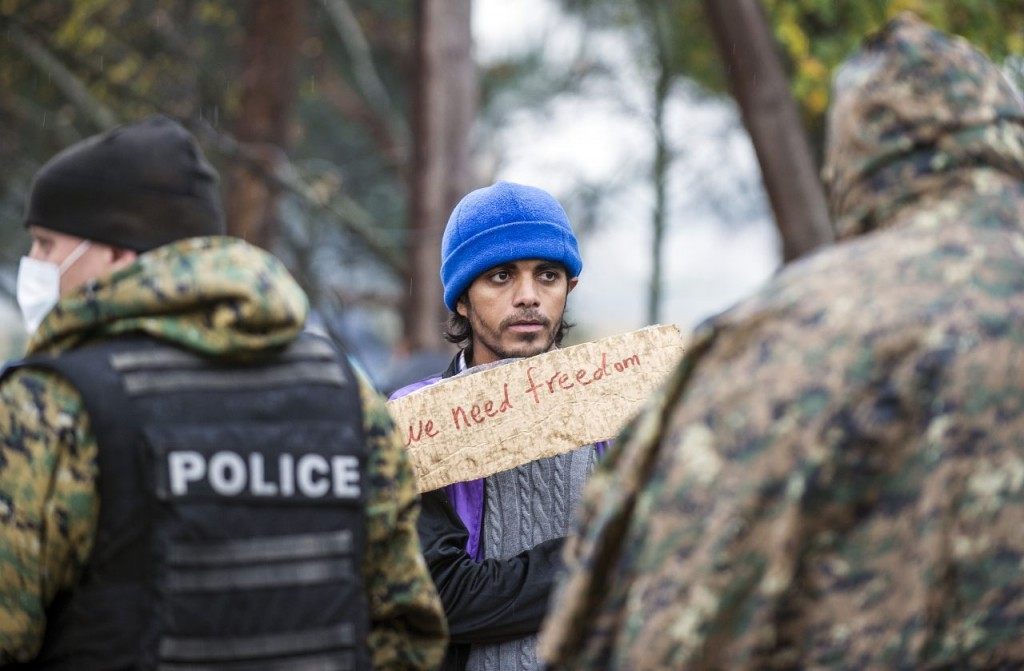 A man stands in front of Macedonian policemen during a demonstration of migrants waiting to cross the Greek-Macedonian border near Gevgelija, on November 25, 2015. Since last week, Macedonia has restricted passage to northern Europe to only Syrians, Iraqis and Afghans who are considered war refugees. All other nationalities are deemed economic migrants and told to turn back. Over 1,500 people are stuck on the border, mostly Indians, Moroccans, Bangladeshis and Pakistanis.AFP PHOTO / ROBERT ATANASOVSKI / AFP / ROBERT ATANASOVSKI (Photo credit should read ROBERT ATANASOVSKI/AFP/Getty Images