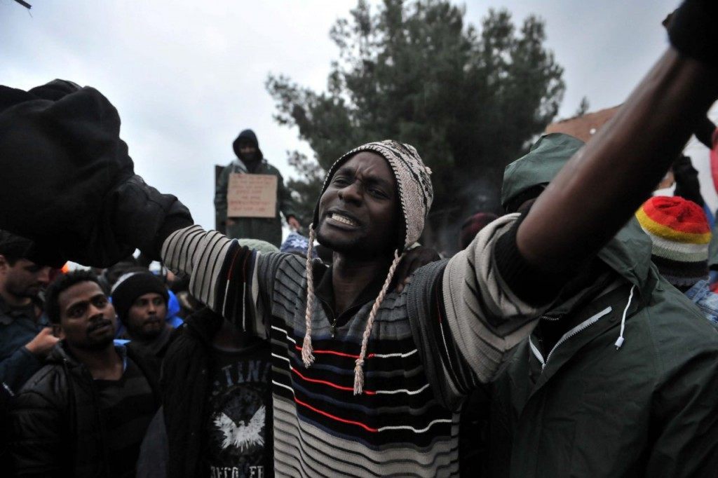 Migrants and refugees from African countries demonstrate as they wait to cross the Greek-Macedonian border near Idomeni on November 25, 2015. Since last week, Macedonia has restricted passage to northern Europe to only Syrians, Iraqis and Afghans who are considered war refugees. All other nationalities are deemed economic migrants and told to turn back. Over 1,500 people are stuck on the border, mostly Indians, Moroccans, Bangladeshis and Pakistanis. AFP PHOTO /Sakis Mitrolidis / AFP / SAKIS MITROLIDIS (Photo credit should read SAKIS MITROLIDIS/AFP/Getty Images)