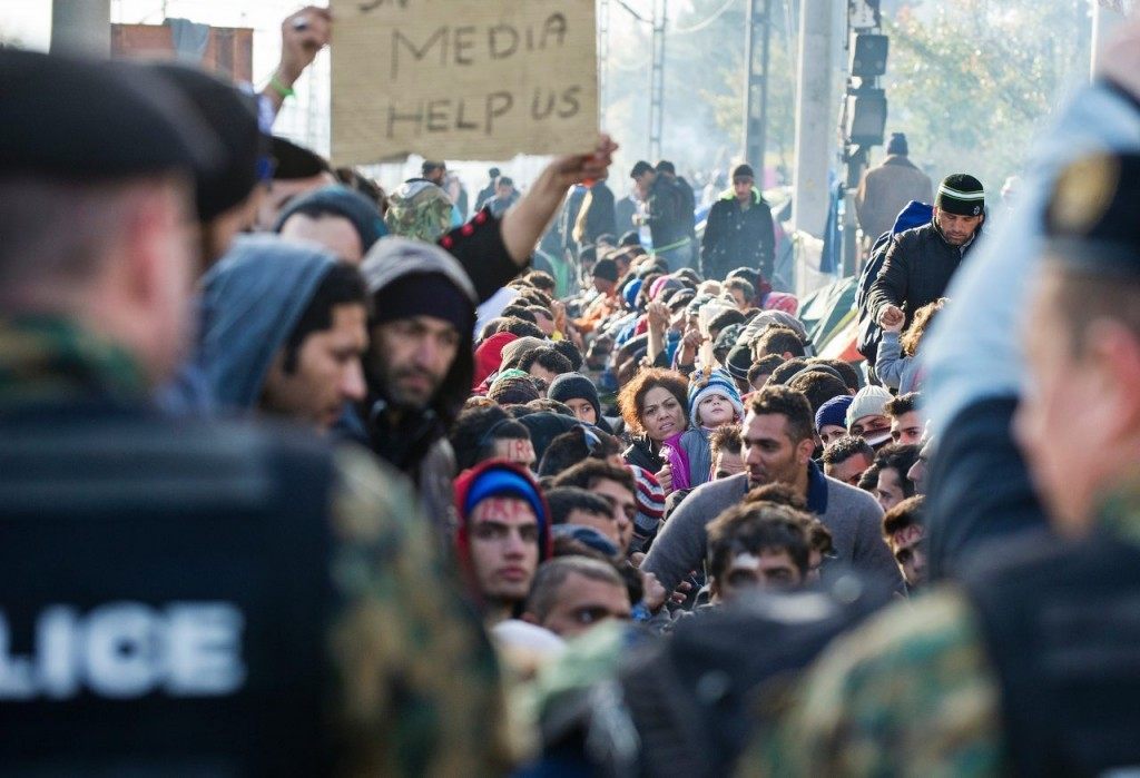 Migrants and refugees protest in front of Macedonian police officers while waiting to cross the Greece-Macedonia border, near Gevgelija, on November 26, 2015. Since last week, Macedonia has restricted passage to northern Europe to only Syrians, Iraqis and Afghans who are considered war refugees. All other nationalities are deemed economic migrants and told to turn back. Over 1,500 people are stuck on the border, mostly Indian, Moroccan, Bangladeshi and Pakistani.AFP PHOTO / ROBERT ATANASOVSKI / AFP / ROBERT ATANASOVSKI (Photo credit should read ROBERT ATANASOVSKI/AFP/Getty Images)