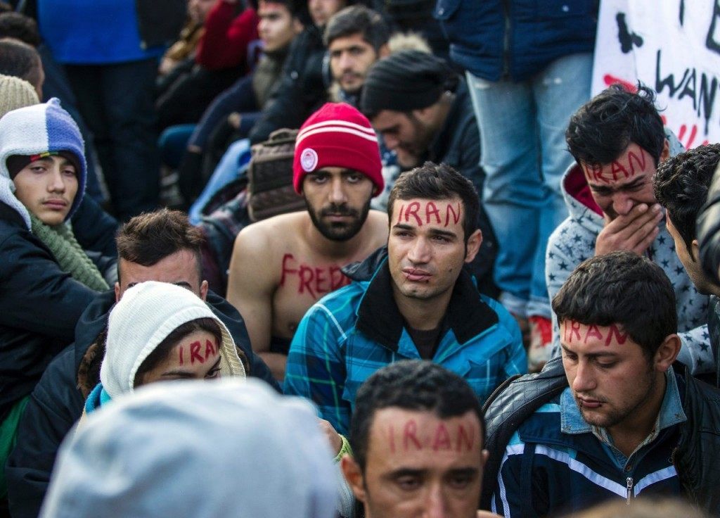Migrants and refugees protest in front of Macedonian police officers while waiting to cross the Greece-Macedonia border, near Gevgelija, on November 26, 2015. Since last week, Macedonia has restricted passage to northern Europe to only Syrians, Iraqis and Afghans who are considered war refugees. All other nationalities are deemed economic migrants and told to turn back. Over 1,500 people are stuck on the border, mostly Indian, Moroccan, Bangladeshi and Pakistani.AFP PHOTO / ROBERT ATANASOVSKI / AFP / ROBERT ATANASOVSKI (Photo credit should read ROBERT ATANASOVSKI/AFP/Getty Images)