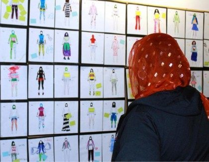 In this June 10, 2015 photo, a woman looks at design drawings for Muslim girls athletic wear before a fashion show in Minneapolis. Muslim girls who play sports have challenges that go beyond the sporting. They worry about tripping on a long, flowing dress, or having a loosely wrapped hijab …