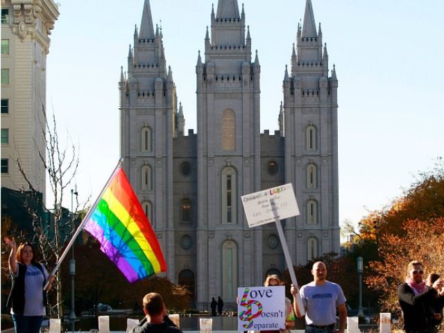 Protesters hold signs and a pride flag in front of the historic Mormon temple after many s