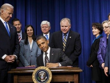 Vice President Biden and members of Congress watch as President Obama signs the STOCK Act on April 4, 2012. A year later, Congress moved to undo large portions of the law without fanfare.