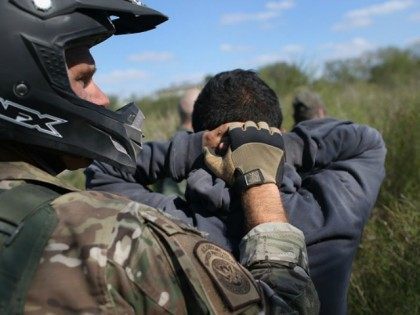 A U.S. Border Patrol agent leads undocumented immigrants through the brush after capturing them near the U.S.-Mexico border on December 7, 2015 near Rio Grande City, Texas. Border Patrol agents continue to detain hundreds of thousands of undocumented immigrants trying to avoid capture after crossing into the United States, even …