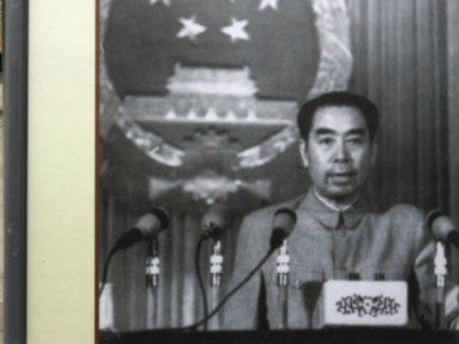A visitor rests beside a picture featuring late Chinese premier Zhou Enlai delivering a sp