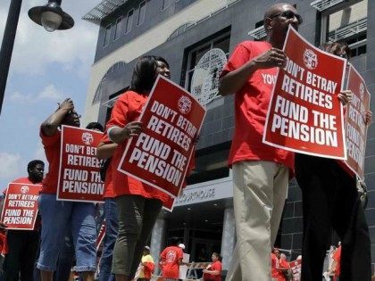 Union members carry protest signs as they march outside the Mercer County Criminal Courtho