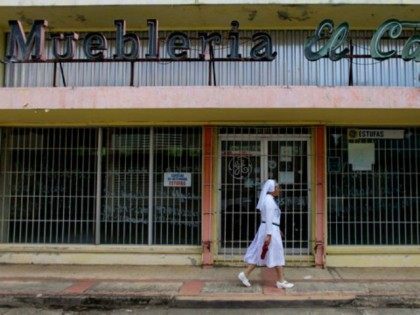 A nun walks in front of a closed furniture store in Lares, Puerto Rico, on September 2, 20