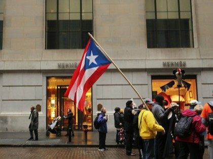 People protest outside of Wall Street against cutbacks and austerity measures forced onto the severely indebted island of Puerto Rico on December 2, 2015 in New York City. Puerto Rico made a $355 million payment on Tuesday on its bond debt to stave off a default. Officials have warned that …