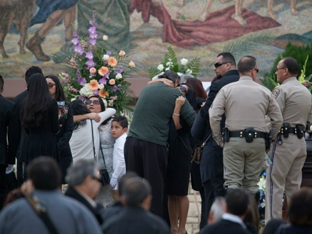amily members hug near the casket of 27-year-old Yvette Velasco at the first funeral for v