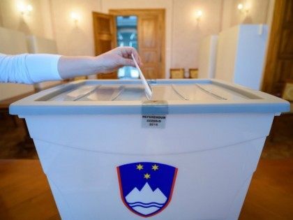 Slovenian citizen casts a ballot at a polling station in Bled Slovenia on December 20, 201