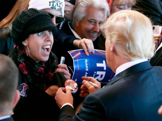 A campaign supporter reacts as Republican presidential candidate Donald Trump signs her bu
