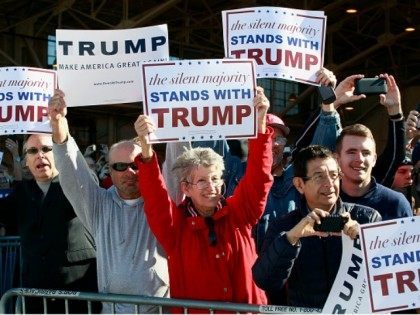 Campaign supporters hold up signs for Republican presidential candidate Donald Trump as hi