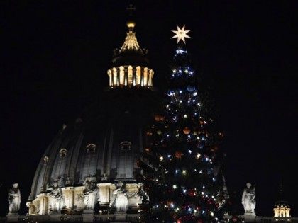 cupola of St Peter's basilica and the Christmas tree after its illumination on December 18, 2015 in Vatican. AFP PHOTO / GABRIEL BOUYS / AFP / GABRIEL BOUYS (Photo credit should read
