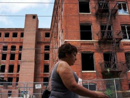A woman walks by a closed factory on May 20, 2013 in Waterbury, Connecticut. Waterbury, on