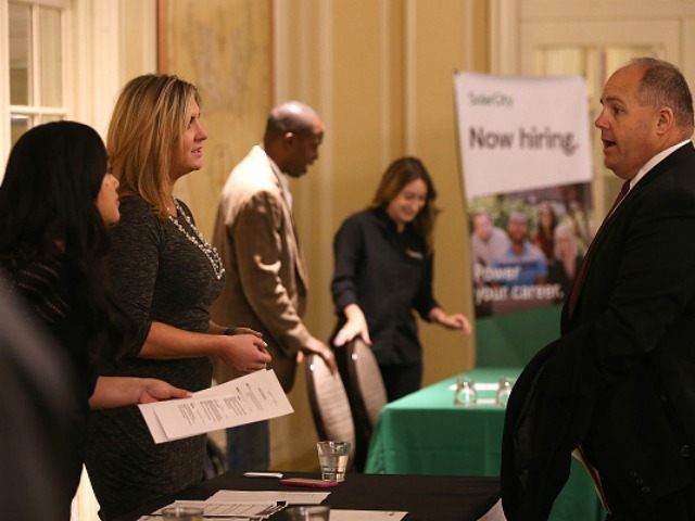 A job seeker (R) meets with recruiters during the HireLive Career Fair on November 12, 201