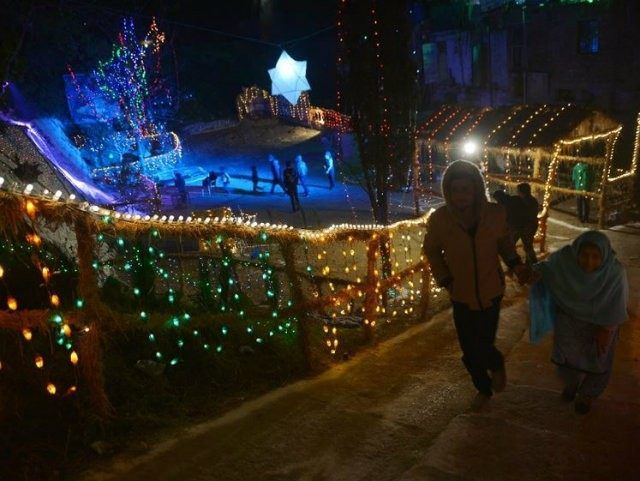Pakistanis walk past Christmas decorations displayed in Islamabad on December …