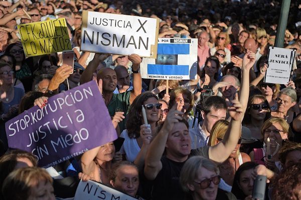People hold signs during a vigil on the first anniversary of Argentinian prosecutor Alberto Nisman's mysterious death in Buenos Aires, on January 18, 2016. The prosecutor died in mysterious circumstances in January 18, 2015, after accusing Argentina's then president, Cristina Fernandez de Kirchner, of obstructing his investigation of a 1994 bombing at a Buenos Aires Jewish center. AFP PHOTO/EITAN ABRAMOVICH. / AFP / EITAN ABRAMOVICH (Photo credit should read EITAN ABRAMOVICH/AFP/Getty Images)