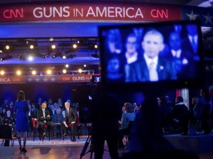 President Barack Obama, center, listens to a question from Taya Kyle, left standing, widow