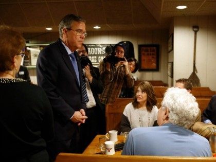 Jeb Bush, left, visits with attendees after speaking at a campaign stop, Wednesday, Jan. 1