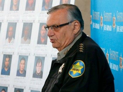 With mug shots of those arrested in the background, Maricopa County Sheriff Joe Arpaio ann