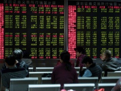 Investors look at screens showing stock market movements at a securities company in Beijin