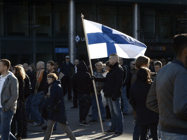 An anti-migration protesters holds a national flag on October 3, 2015 in Helsinki. Several