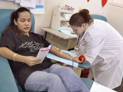 GLENVIEW, IL - JANUARY 16: Phlebotomist Andrea Abbatte (R) monitors Lirio Romo as she don