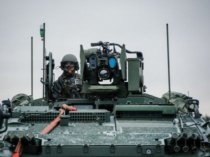 A soldier from the Swedish Armed Forces, looks on from top of the Patria XA-360 AMV (Armo