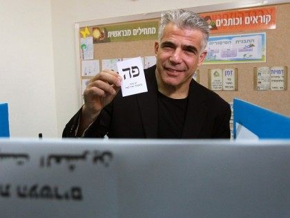 Israeli MP and chairperson of center-right Yesh Atid party, Yair Lapid, prepares to cast his ballot at a polling station, on March 17, 2015 in Tel Aviv. Voting polls opened for unpredictable elections to determine whether Israelis still want incumbent Prime Minister Benjamin Netanyahu as leader, or will seek change …