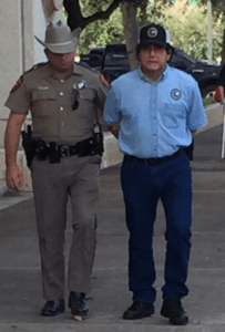 Tax office employee Jose Mireles is taken into custody by Texas DPS during the raid. 
