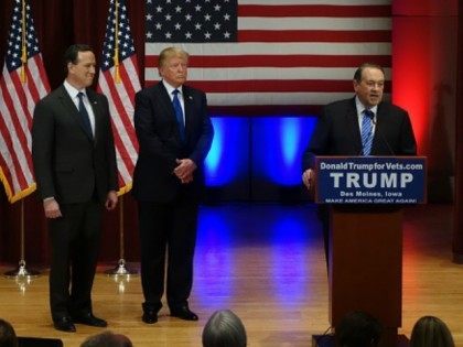 onald Trump (C) looks on with Rick Santorm (L) as Mike Huckabee speaks during a Trump campaign rally raising funds for US military veterans at Drake University in Des Moines, Iowa on January 28, 2016. US Republicans scrambling to win the first contest in the presidential nomination race were gearing …
