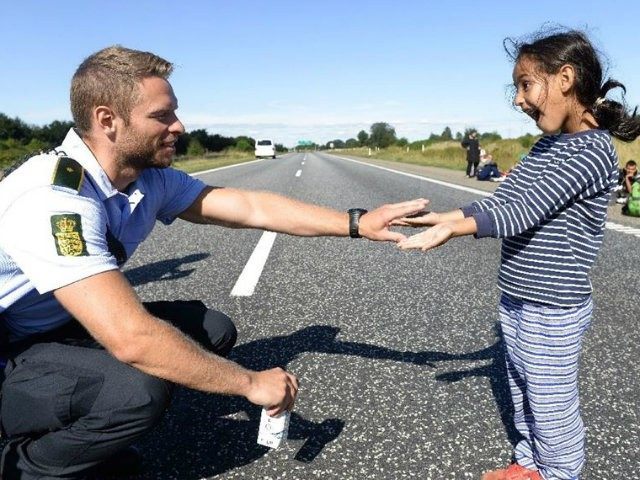 A Danish policeman meets a migrant girl as a group …