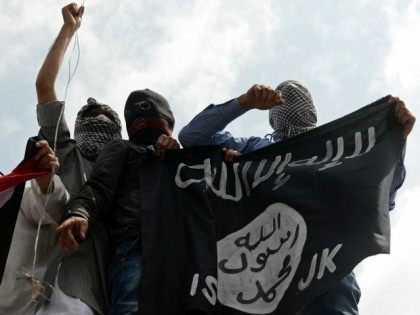 INDIA, Srinagar : Kashmiri demonstrators hold up a flag of the Islamic State of Iraq and t