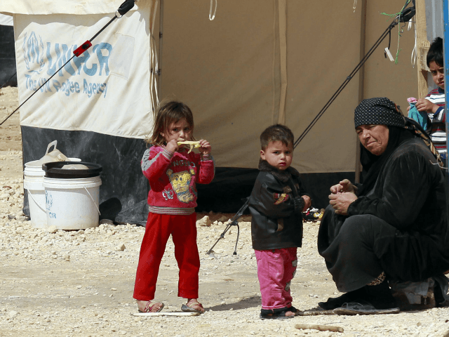This picture, taken on March 15, 2014, shows a family at the sprawling desert Zaatari refugee camp in northern Jordan near the border with Syria which provides shelter to around 100,000 Syrian refugees. (Khalil Mazraawi/AFP via Getty Images)
