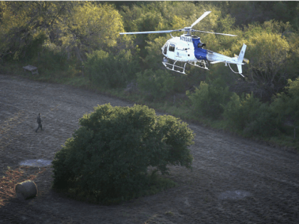 A helicopter from U.S. Air and Marine Operations (AMO), searches for undocumented immigrants near the U.S.-Mexico border on December 9, 2015 at near Mission, Texas. The number of migrant families and unaccompanied minors from Central America crossing into the U.S. has again surged in recent months. (Photo by