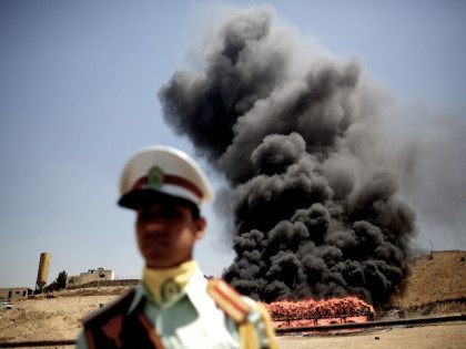 An Iranian employee of the anti-drug police watches 50 tons of drugs seized in recent months burning in eastern Tehran on June 26, 2013 to mark the International Day Against Drug Abuse and Illicit Trafficking. AFP PHOTO/BEHROUZ MEHRI (Photo credit should read BEHROUZ MEHRI/AFP/Getty Images)