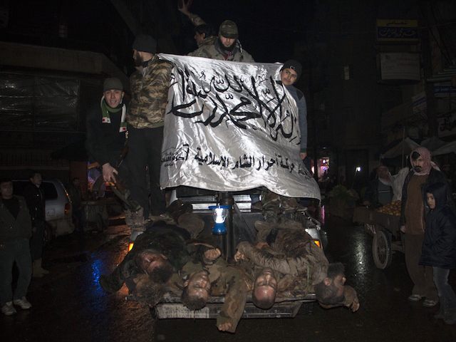 Opposition fighters, wave the flag of Ahrar al-Sham brigade, as they parade in the norther