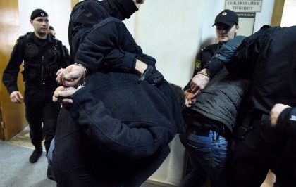 Unidentified suspects detained over the killing of Russian opposition activist Boris Nemtsov are escorted by policemen in a court corridor in Moscow on March 8, 2015.