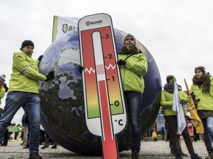 BERLIN, GERMANY - NOVEMBER 29: A woman stays in front of a model of the earth holding a thermometer as activists participate in the Global Climate March on November 29, 2015 in Berlin, Germany. The COP21 2015 Paris Climate Conference will begin on November 30, though due to the recent …