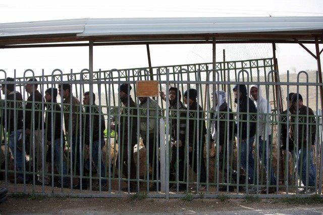 Palestinian workers exit the Tekoa settlement south of Jerusalem on January 18, 2016, afte